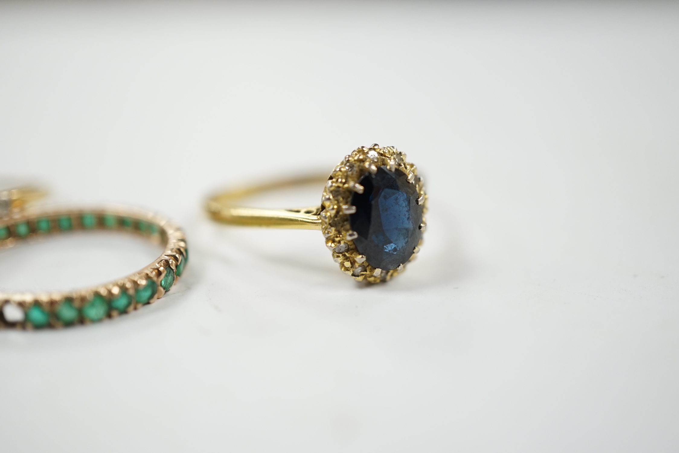 A 1920's 18ct and plat, sapphire and diamond set flower head cluster ring, size L, a 1960's 18ct gold sapphire and diamond set oval cluster ring and a yellow metal and emerald chip set full eternity ring, gross weight 6.